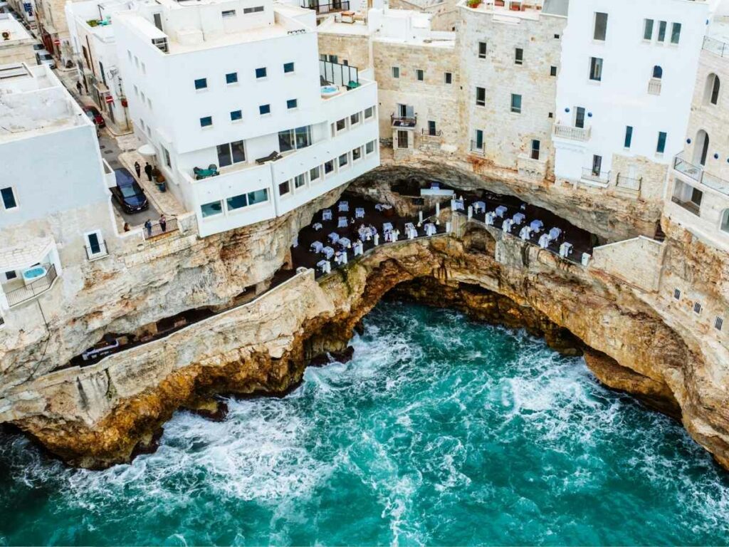 vista dall'alto del ristorante grotta palazzese a polignano a mare, all'interno di una scogliera, a strapiompo sul mare